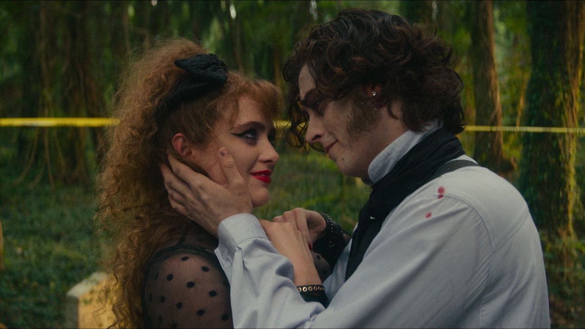 Young couple is hugging each other in a wooded are. Lisa Swallows is in Goth clothes and the Creature is in Victorian clothes.