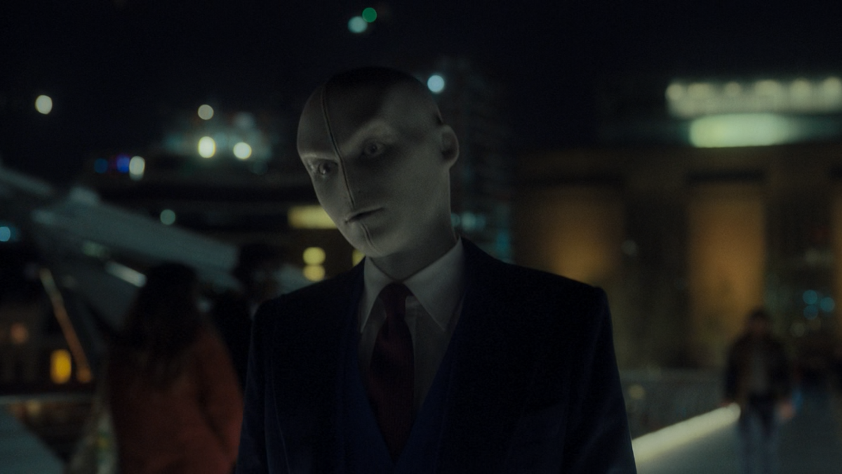The Chameleon (a bold, mannequin looking man in suit) is in mid transform.