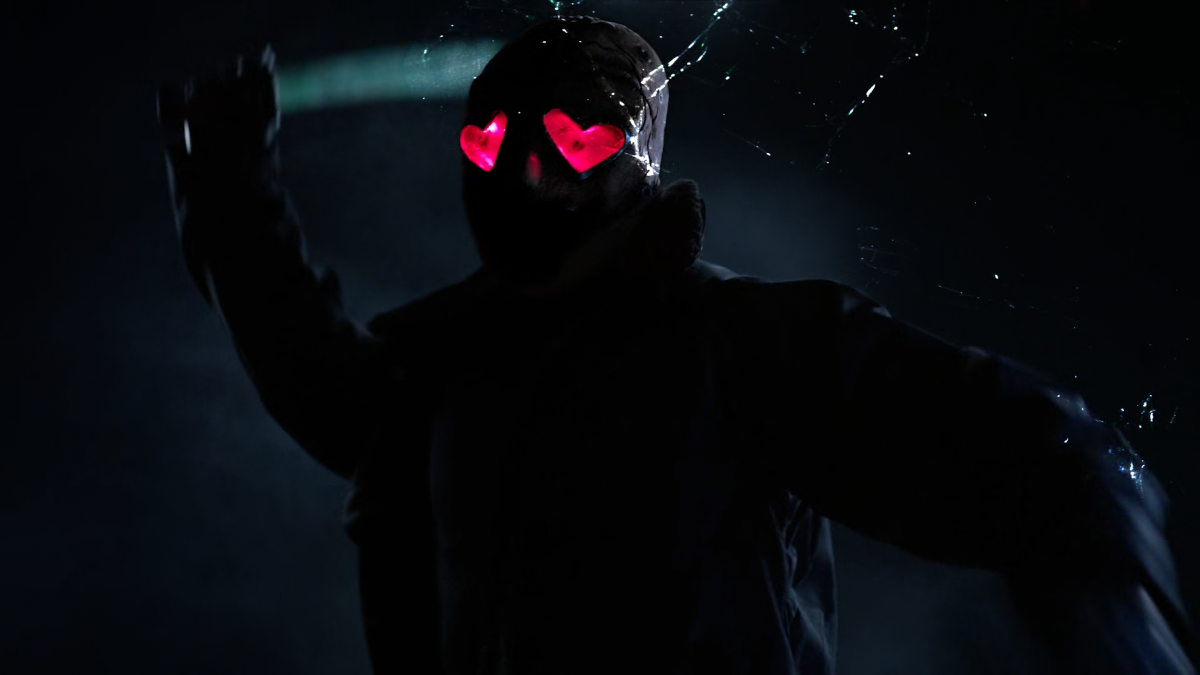 Creepy looking masked man is attacking with a machete. He is in the dark, wearing black clothes. Heart shaped eye slots of his mask are glowing red in the dark.