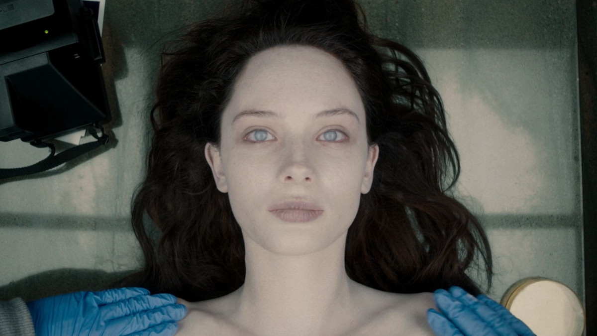 Jane Doe is on an autopsy table. Her eyes are open.