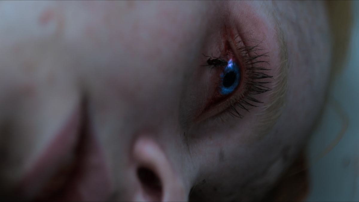 A fly has landed on Hannah Grace’s eye. That eye is glowing blue.