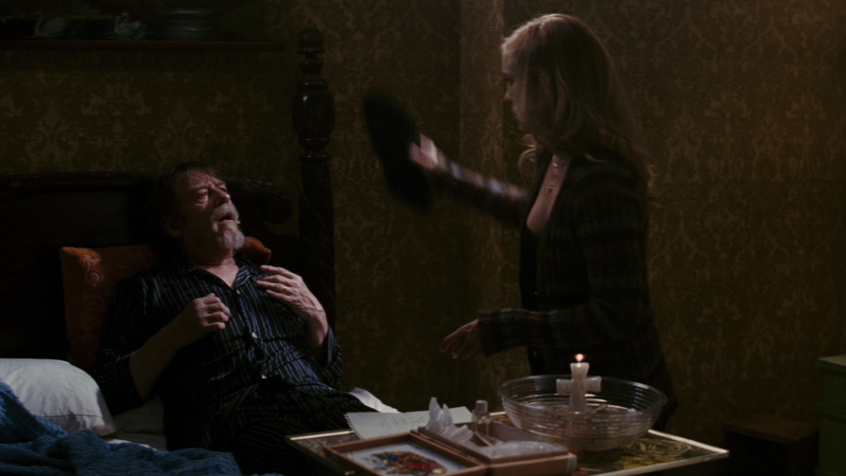 A young woman (Caroline) is performing a Hoodoo ritual over paralyzed old man Ben.